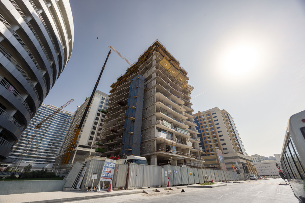 Cove Edition I By Imtiaz 1 A construction site featuring a tall building under development, surrounded by modern architecture and a clear blue sky.